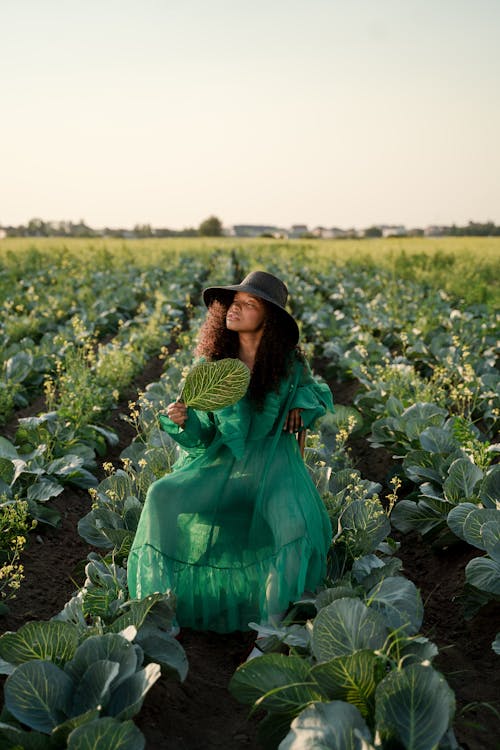 Woman in Green Dress Sitting in Cabbage Field