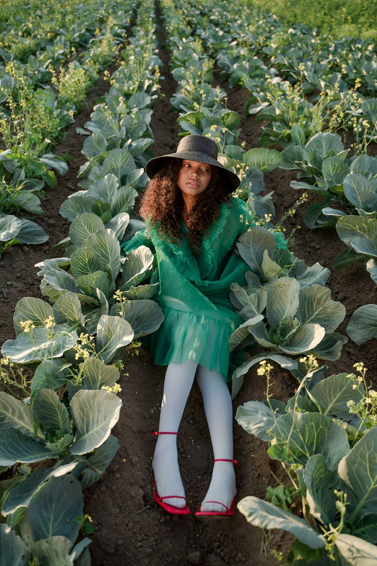 Woman In Green Dress And White Thighs Sitting In Cabbage Field 