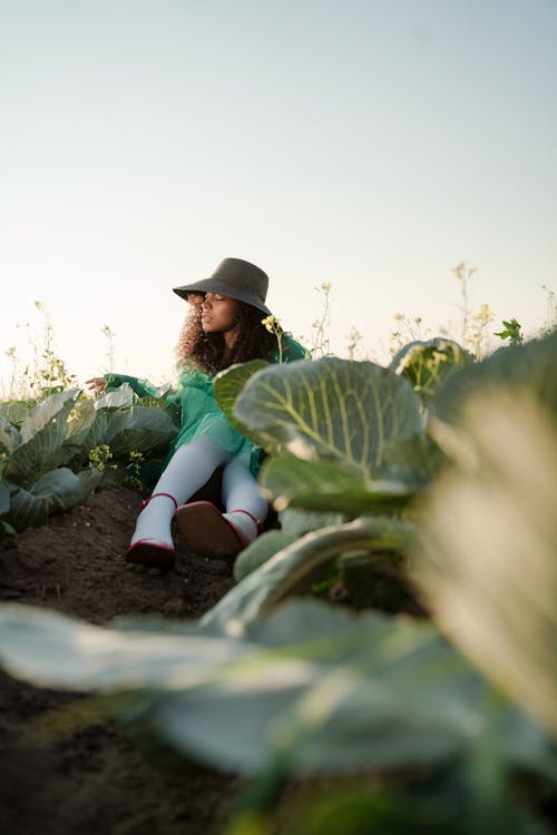 Woman in Green Dress Sitting in Cabbage Field