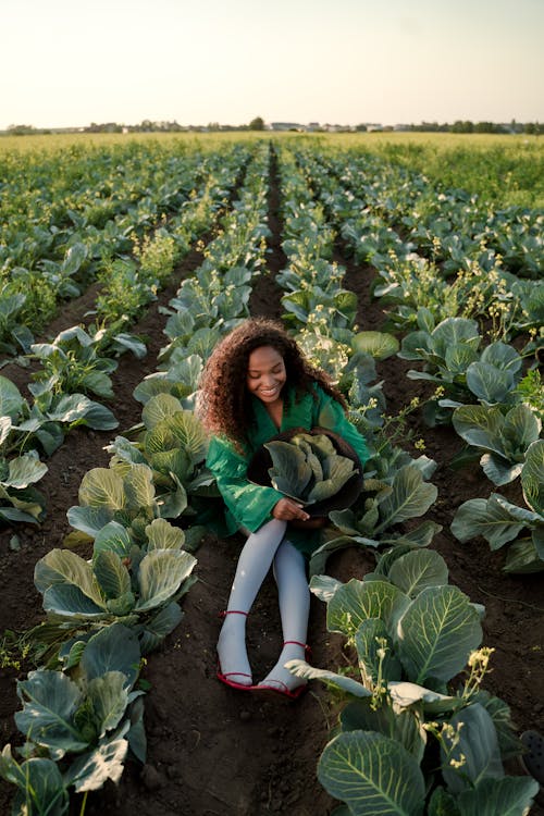 Woman in Green Dress and White Thighs Sitting in Cabbage Field 