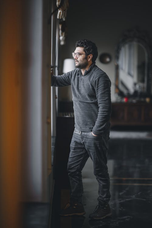 A Man in Gray Sweater Standing with His Hand on His Pocket