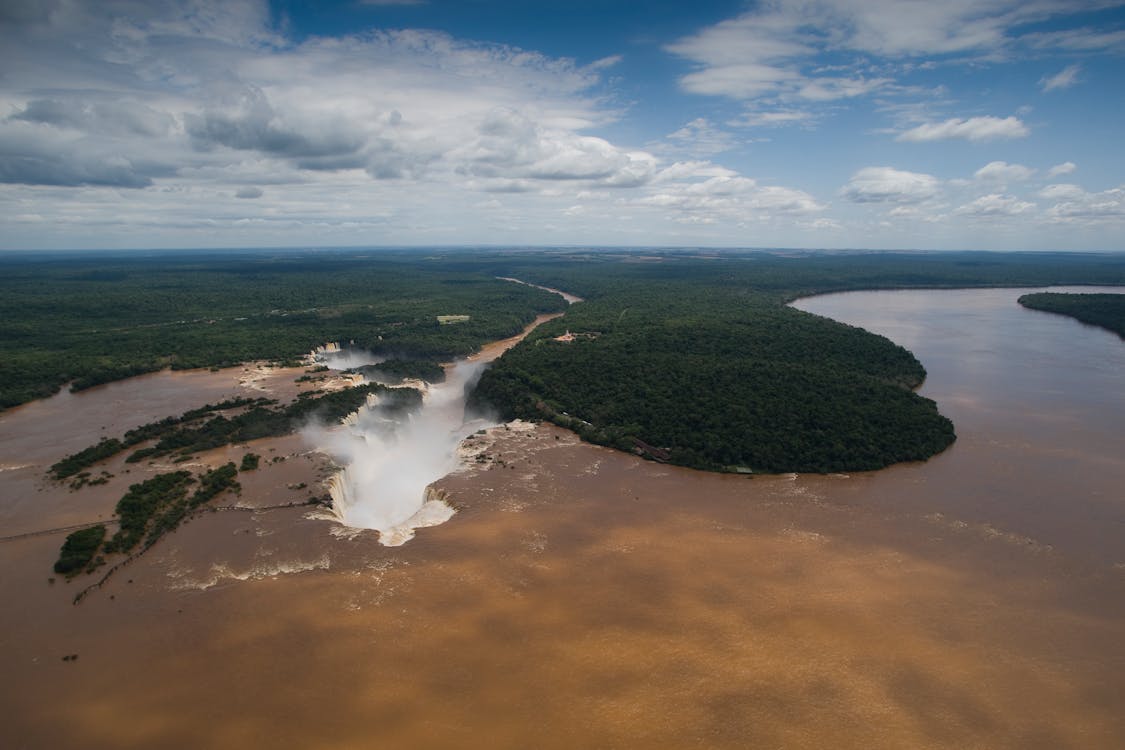 Aerial Shot of a Large River with a Waterfall