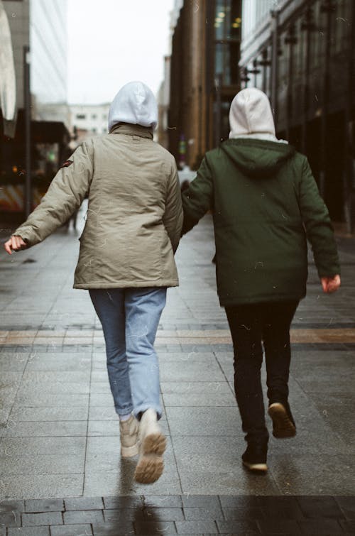 Free Two People in Hoodie Jackets Walking on the Street Stock Photo