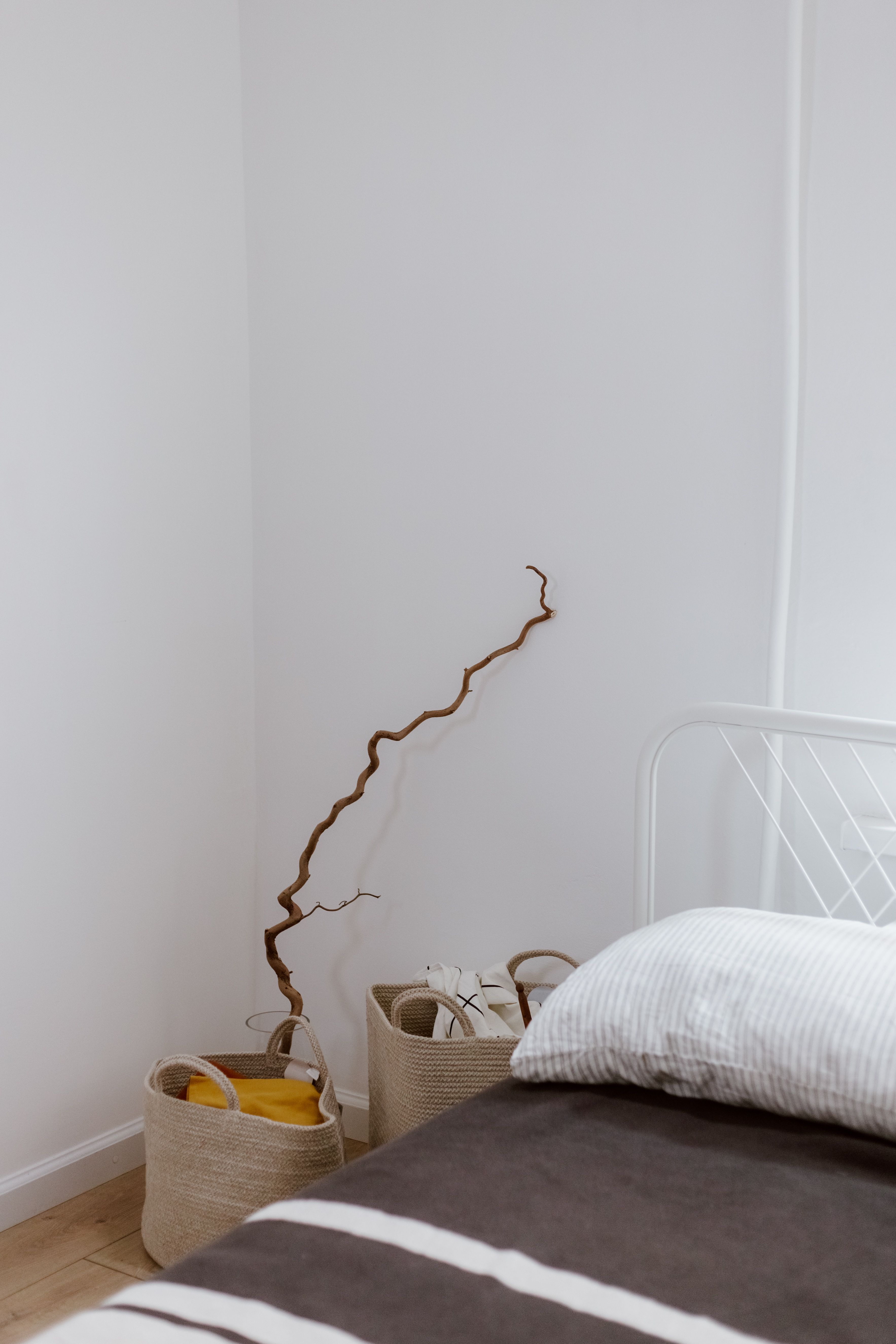 Woven storage baskets keeping a bedroom corner tidy