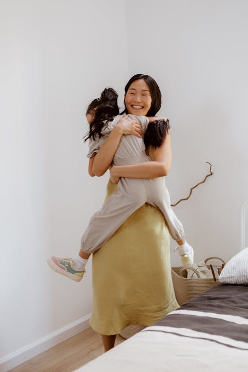 Mother Hugging Daughter in the Bedroom