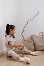 Girl Sitting on the Floor and Building a Tower of Blocks 