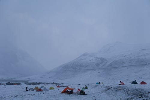 People Camping on a Snow Covered Mountain