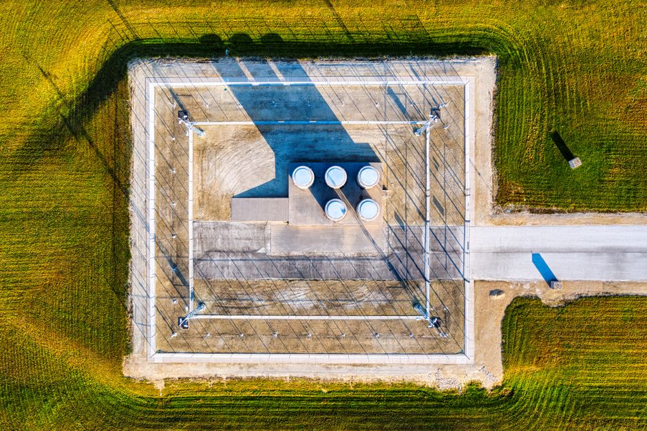 Aerial view of an industrial complex in Genoa, WI, under the summer sun showcasing shadows and containers.
