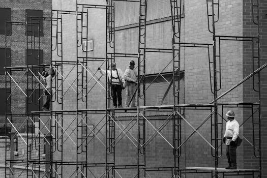 Black and white photo of construction workers on scaffolding in New York City.
