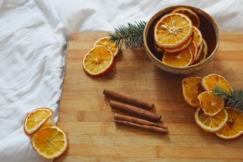 Free Slices of Dried Orange Fruit and Cinnamon Sticks on Wooden Table Stock Photo