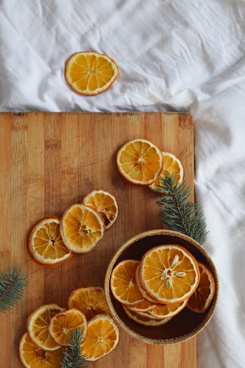 Sliced Orange Fruit on Brown Wooden Chopping Board