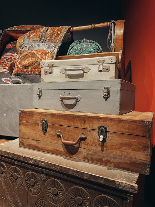Free A collection of vintage suitcases and colorful antique textiles in a cozy indoor setting. Stock Photo