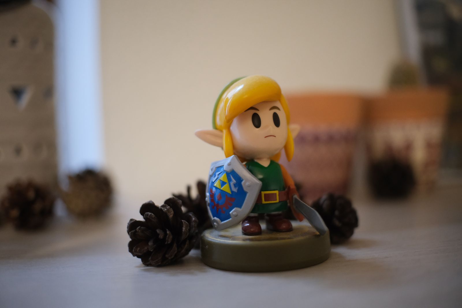 Figurine de héros elfe de jeu vidéo avec épée et bouclier parmi des pommes de pin