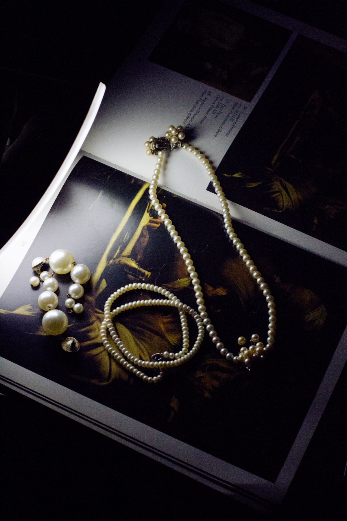 Pearl necklaces resting on a magazine