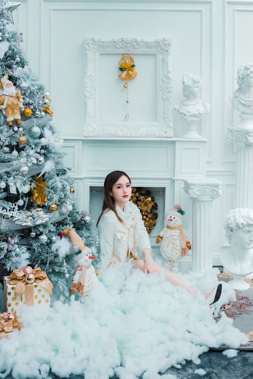 Free Young Woman Sitting by Christmas Tree Stock Photo