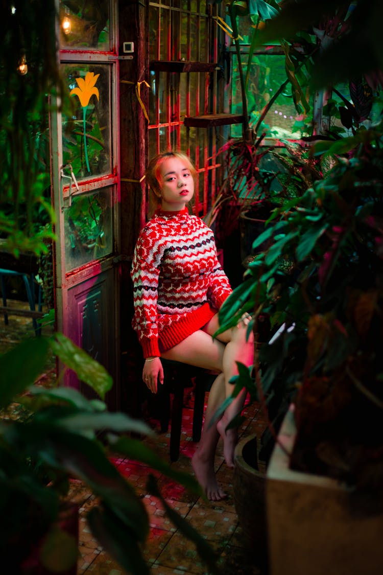 Woman Sitting On A Chair Inside A Indoor Garden