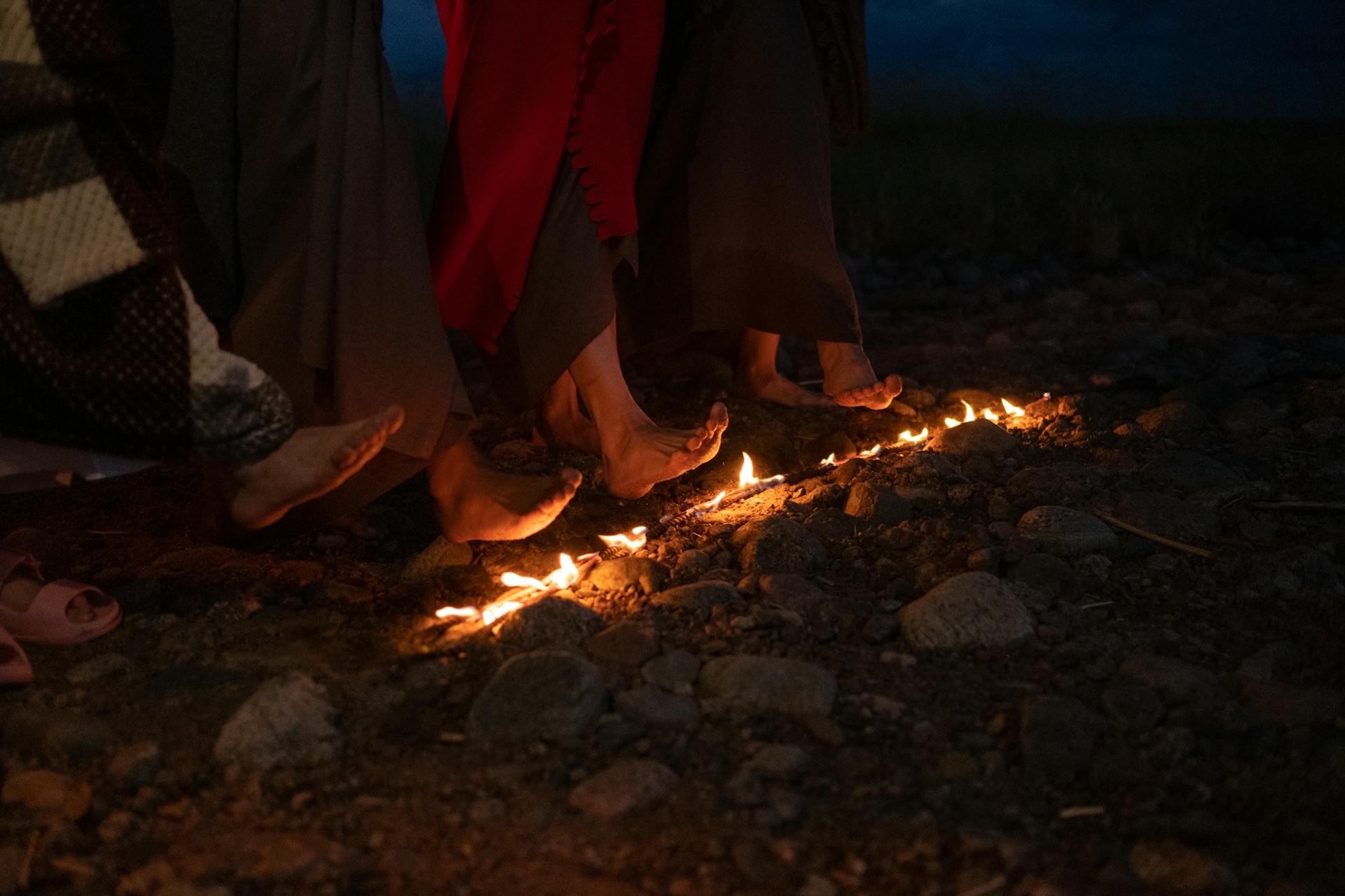 People  Heating their Feet on a Burning Stick on Ground