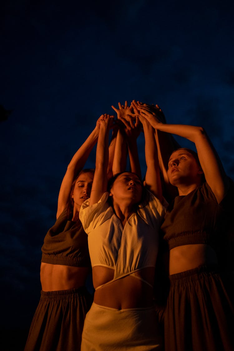 Women Raising Their Arms Together