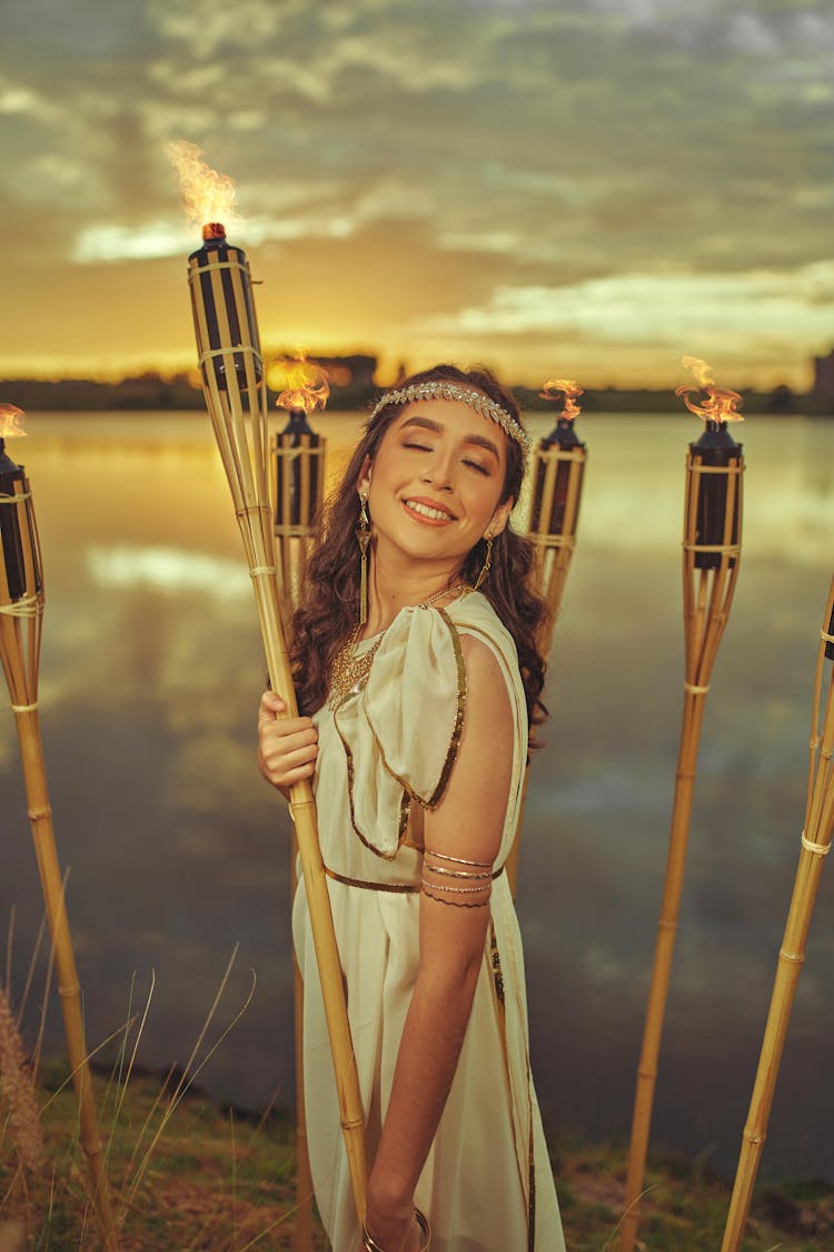 A Woman Smiling While Holding A Torch