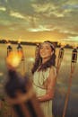 Woman in White Dress Near Burning Torches