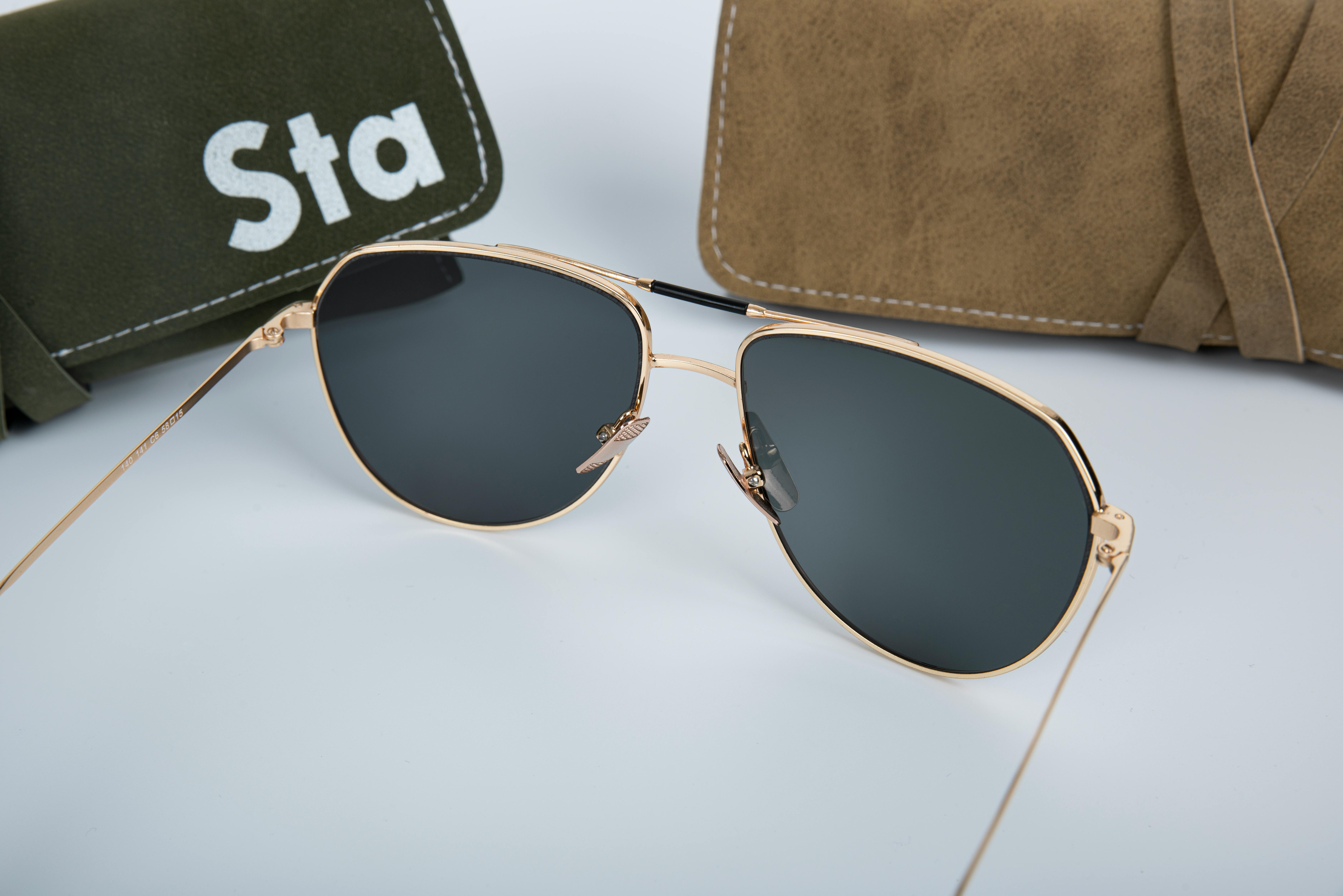 Close-up of chic aviator sunglasses with leather and suede cases. Perfect for fashion-forward style.