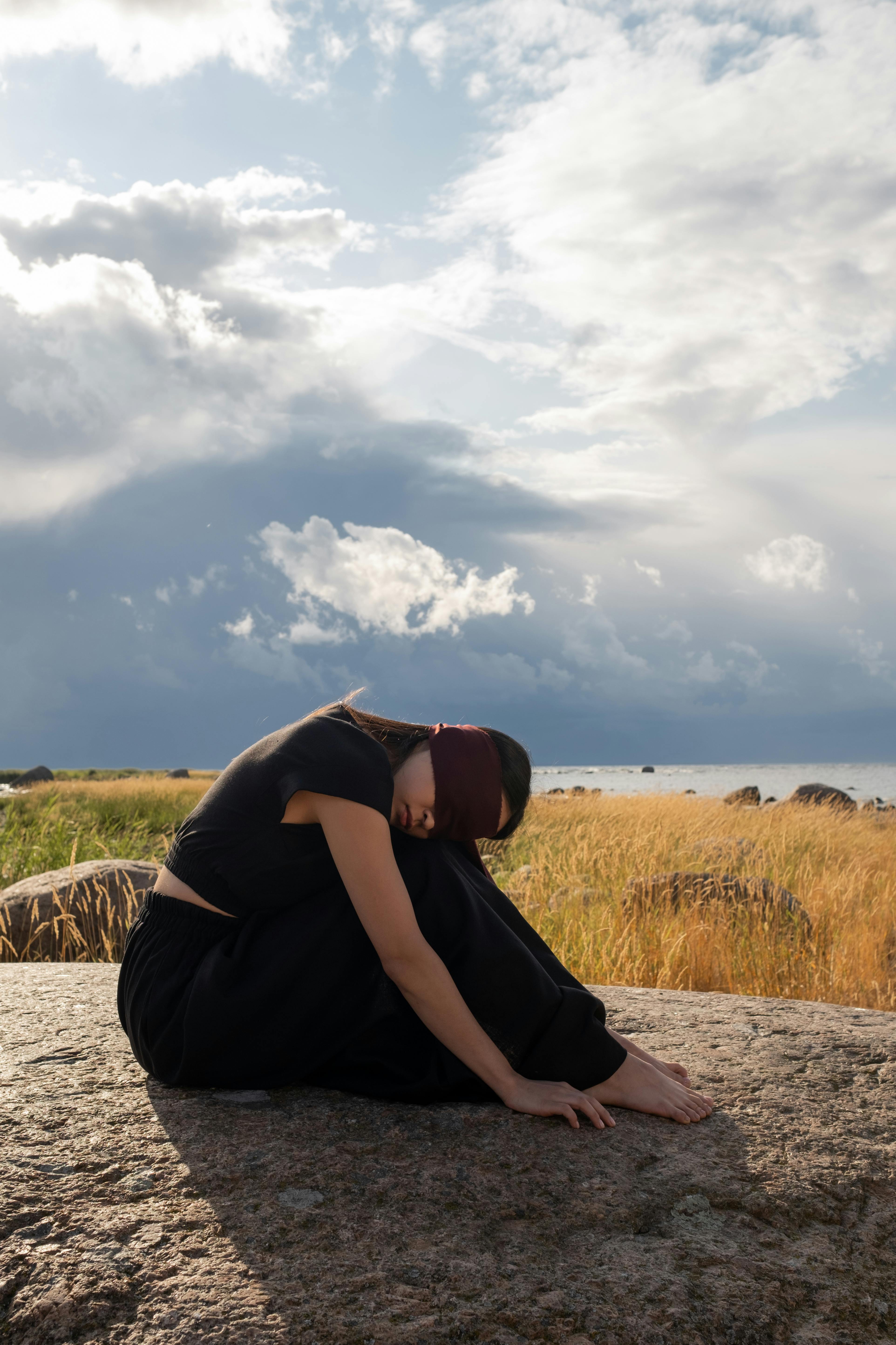 blindfolded woman on a rock