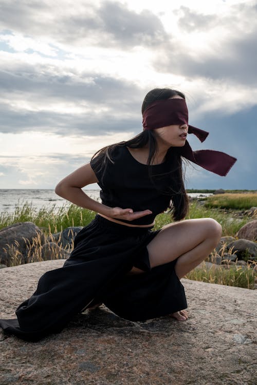 Blindfolded Woman Dancing on a Rock