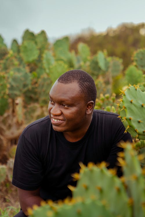 A Man in Black Crew Neck T-shirt Near Green Cactus