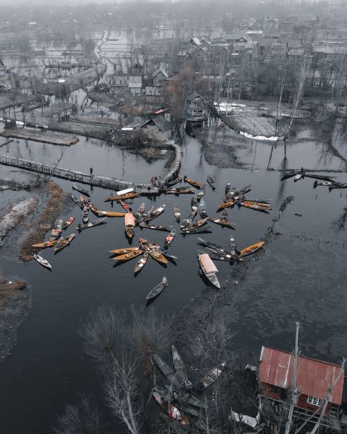 Free A captivating drone shot of boats gathered on Dal Lake, Srinagar, surrounded by serene winter landscapes. Stock Photo