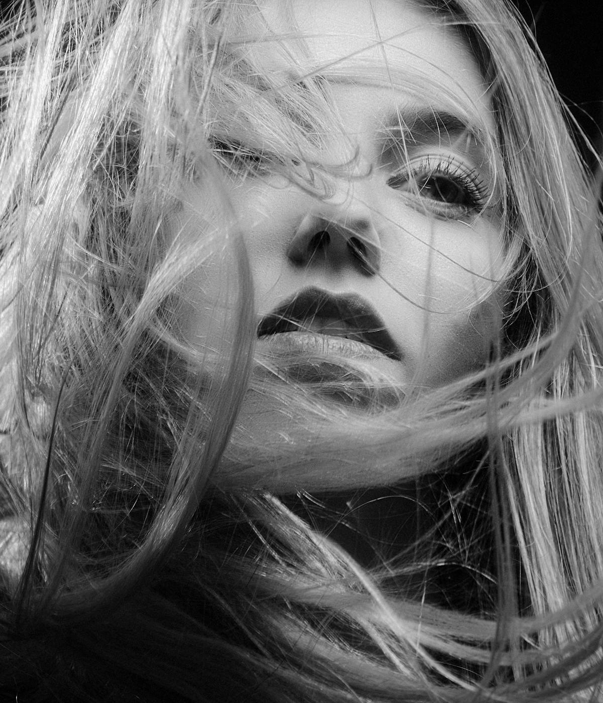 The webpage features a black and white close-up photo of a woman with blonde hair on the left, and text on the right that reads: SUSTAINABILITY. What we do for you.