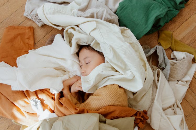 Kid In Pile Of Clothes