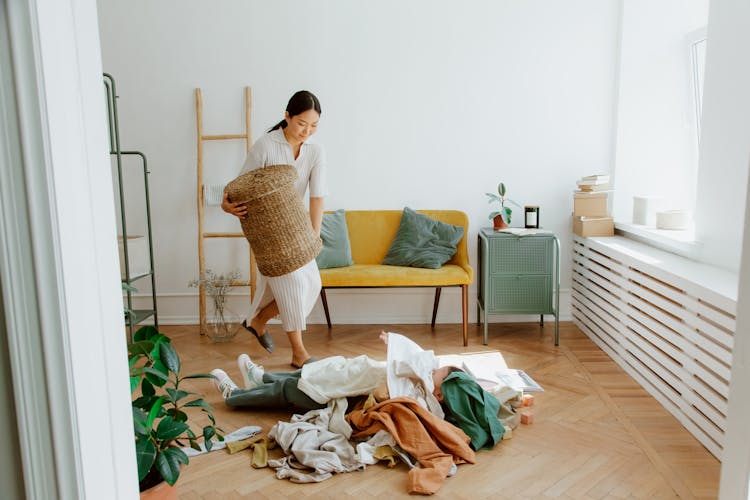 Mother And Daughter Playing While Cleaning Up Clothes