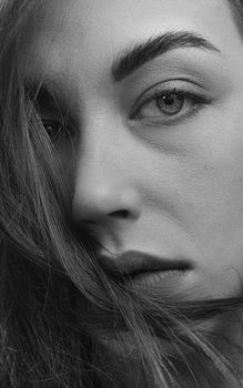 Close-up black and white portrait of a woman with intense gaze.