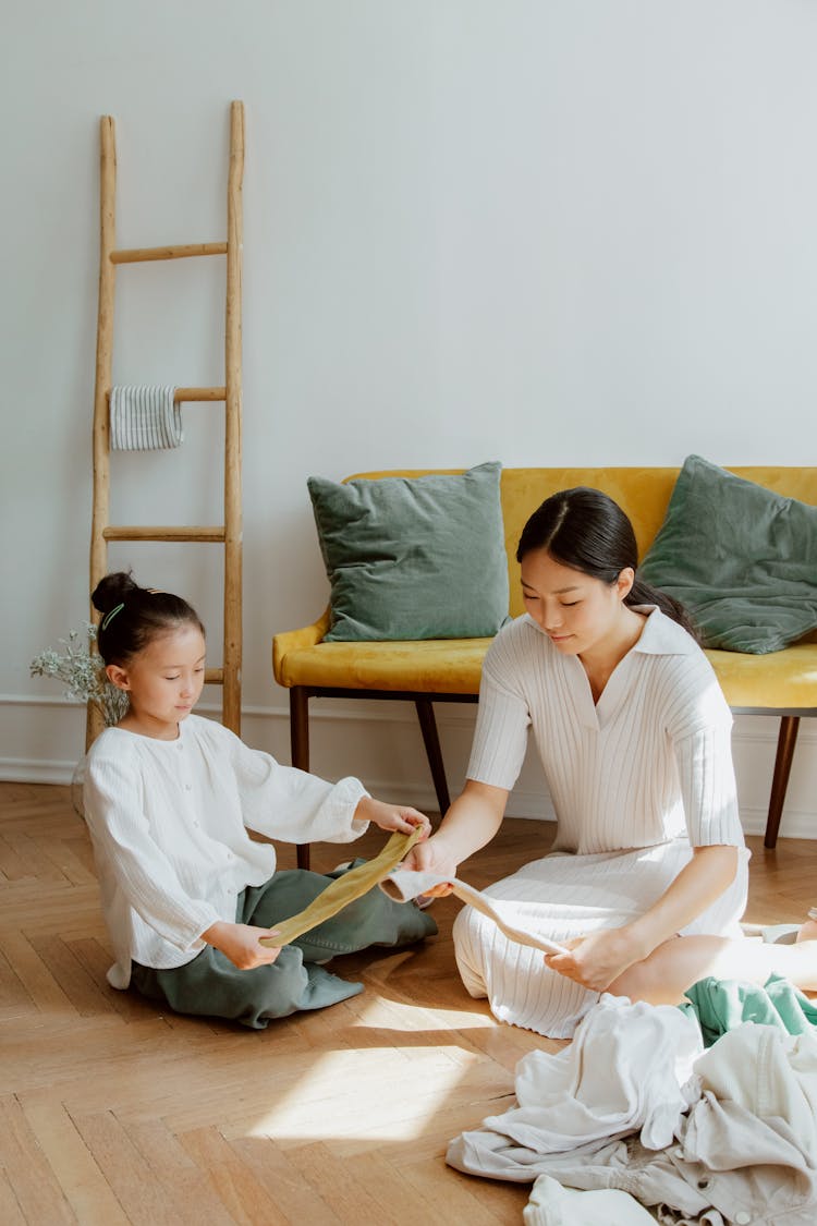 Mother And Daughter Folding Clothes