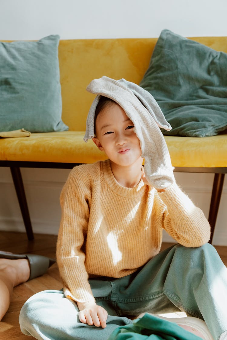 Girl With Socks On Her Head Sitting On Floor