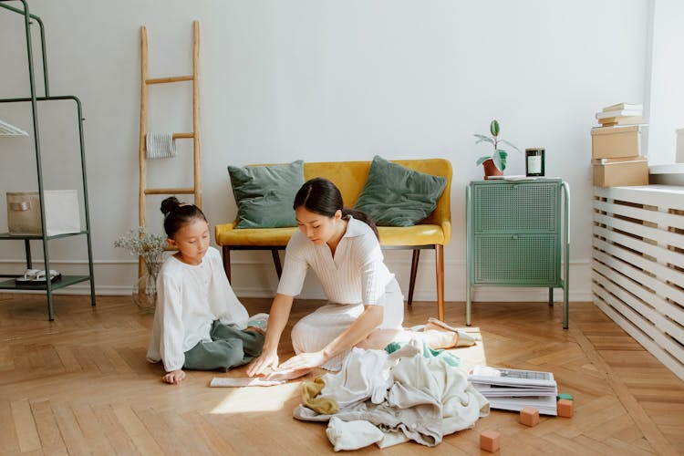 Mother Teaching Daughter Folding Clothes