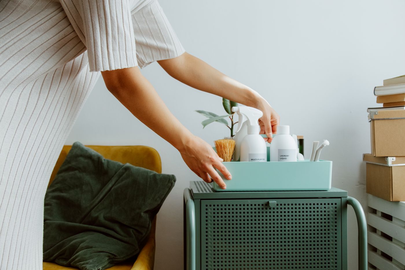 Woman carefully organizing self-care bottles and hygiene products in a bright room