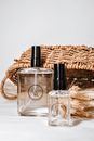 Aesthetic Glass Bottles of Branded Fragrances with Straw Basket in Background