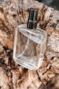 Photographic Composition of Glass Bottle of Perfume Placed on Cut Tree Trunk