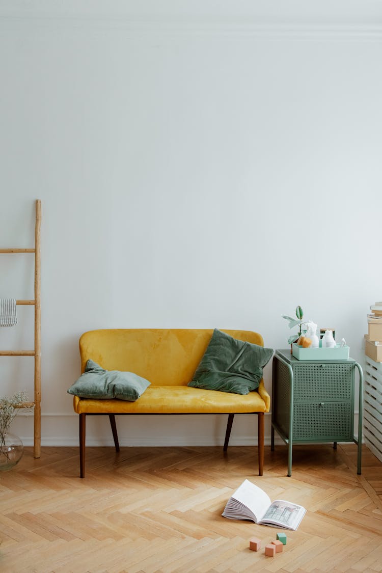 Pillows On Sofa And Toys On Wooden Floor In Living Room