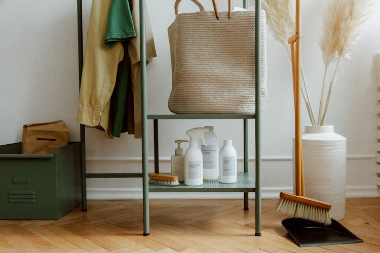 Cleaning Products In Bottles And Bag Laying On Metal Shelves