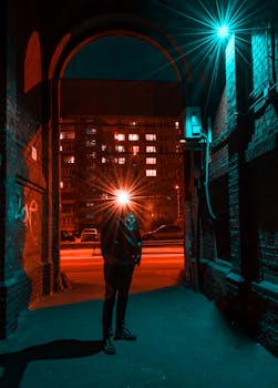 夜晚，一个孤独的人影站在灯火通明、充满活力的城市小巷中，构成了戏剧性的城市景观