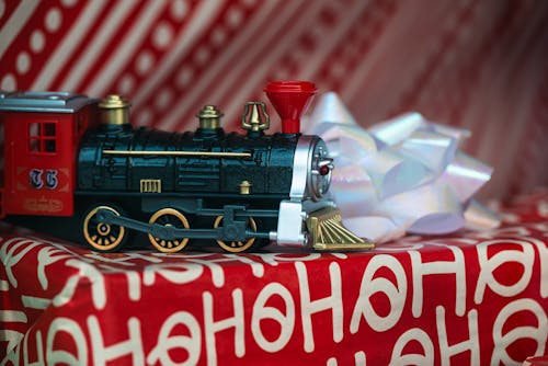 Free Black and Red Toy Train on Top of a Gift Box with Ribbon Stock Photo
