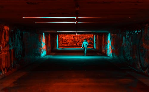 Personne Portant Une Veste Marchant Sur Un Tunnel Avec Des Lumières Rouges Et Vertes