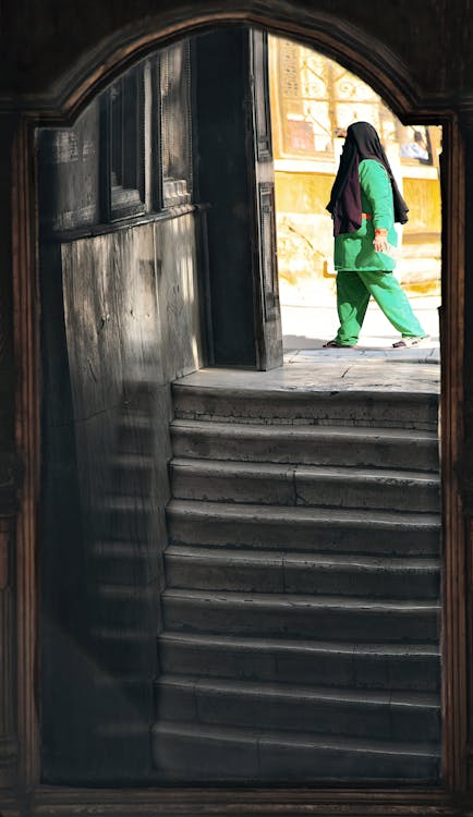 A Person in Green Outfit About to Go Down on the Stairs