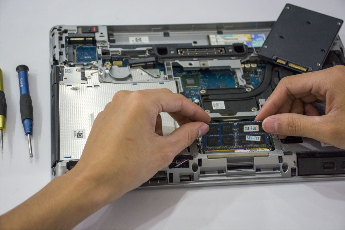 Technician working on internal storage components inside a laptop