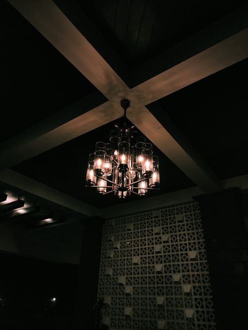 Free A stylish chandelier casting warm light in a modern interior with intricate ceiling design. Stock Photo