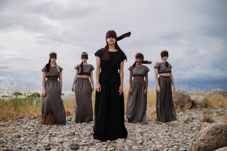 Blindfolded Women Standing On A Rocky Ground