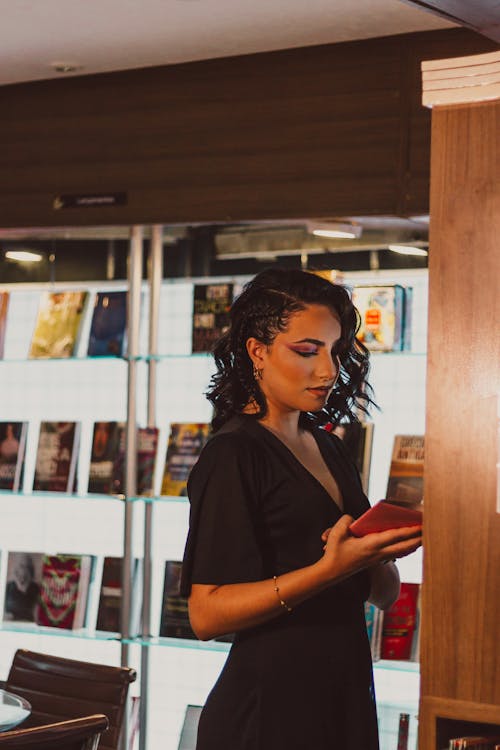 Free Woman in Black Dress Holding a Book Stock Photo