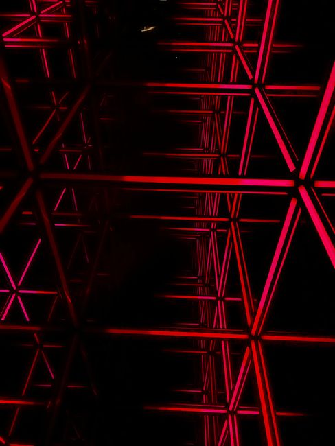 Abstract view of a glowing red geometric framework against a black backdrop, highlighting modern architecture.